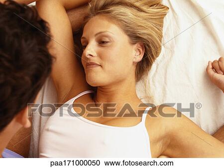 Stock Image - Couple in bed, close-up. Fotosearch