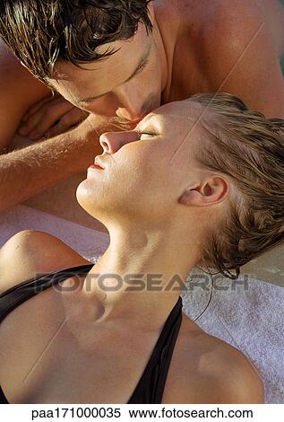 Couple lying down, man kissing woman's forehead, close-up View Large Photo Image Stock Photography - Couple lying down, man kissing woman's forehead, close-up. Fotosearch