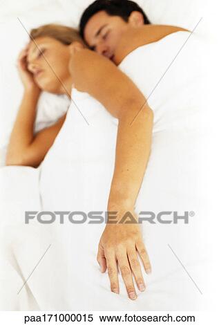 Couple sleeping in bed, focus on woman's hand in foreground View Large Photo Image Stock Photography - Couple sleeping in bed, focus on woman's hand in foreground. Fotosearch