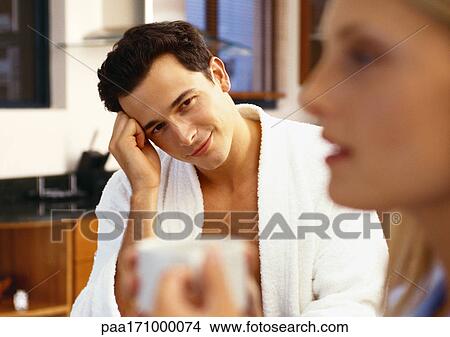 Man with head on hand looking at woman in blurred foreground View Large Photo Image Picture - Man with head on hand looking at woman in blurred foreground. Fotosearch