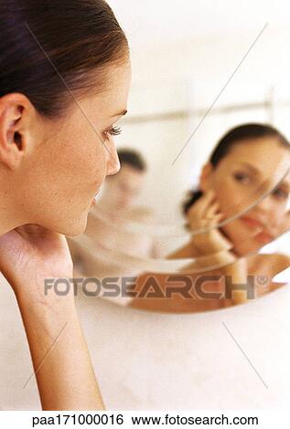 Woman looking at self in mirror View Large Photo Image Stock Photograph - Woman looking at self in mirror. Fotosearch