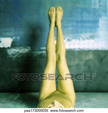 Woman lying on floor with legs in air, elevated view View Large Photo Image Stock Photography - Woman lying on floor with legs in air, elevated view. Fotosearch