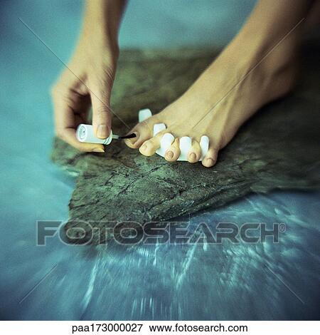 Woman's hand polishing toenails, close-up View Large Photo Image Stock Photo - Woman's hand polishing toenails, close-up. Fotosearch