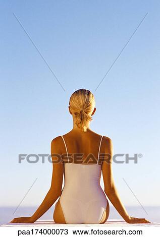 Woman in one-piece bathing suit, hands out to the side, waist up, rear view, blue sky in background View Large Photo Image Stock Image - Woman in one-piece bathing suit, hands out to the side, waist up, rear view, blue sky in background. Fotosearch