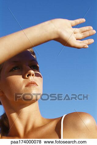 Woman protecting eyes from sun with hand, close-up View Large Photo Image Stock Photo - Woman protecting eyes from sun with hand, close-up. Fotosearch
