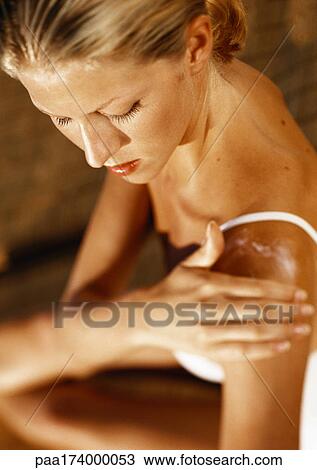 Woman putting lotion on shoulder, high angle view View Large Photo Image Stock Image - Woman putting lotion on shoulder, high angle view. Fotosearch