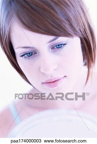 Stock Image - Woman's face, looking down, close-up. Fotosearch