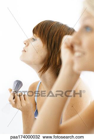 Women putting make-up on, side view, blurred foreground View Large Photo Image Stock Image - Women putting make-up on, side view, blurred foreground. Fotosearch