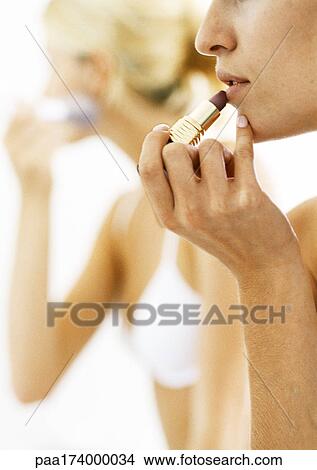 Women putting on make-up, side view, close-up View Large Photo Image Picture - Women putting on make-up, side view, close-up. Fotosearch