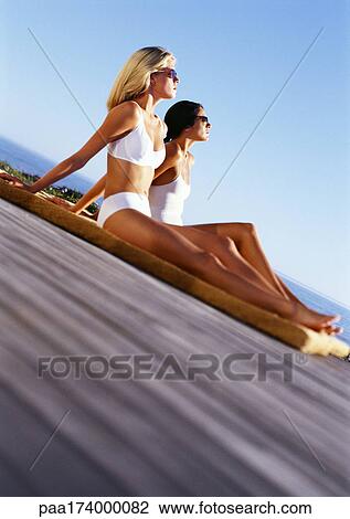 Women with sunglasses sunbathing View Large Photo Image Stock Image - Women with sunglasses sunbathing. Fotosearch