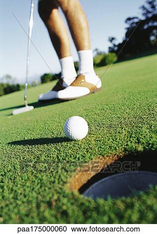 Golfer and golf ball near hole, low section View Large Photo Image Stock Image - Golfer and golf ball near hole, low section. Fotosearch