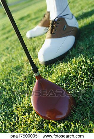 Stock Image - Golfer's feet and club, close-up. Fotosearch