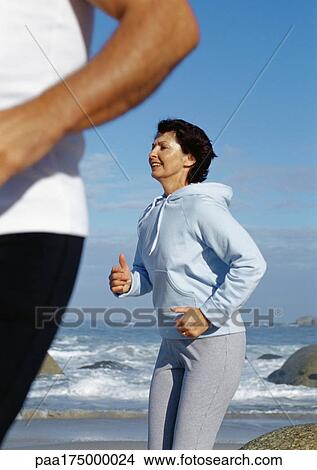Mature couple running on beach View Large Photo Image Picture - Mature couple running on beach. Fotosearch
