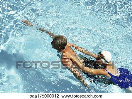 Mature couple swimming in pool, elevated view View Large Photo Image Stock Image - Mature couple swimming in pool, elevated view. Fotosearch