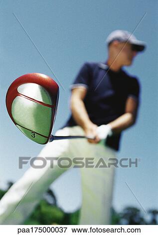 Mature man holding golf club, low angle view, blurred View Large Photo Image Stock Photo - Mature man holding golf club, low angle view, blurred. Fotosearch