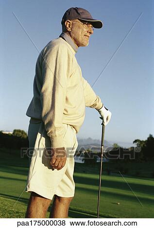 Mature man leaning on golf club View Large Photo Image Stock Photo - Mature man leaning on golf club. Fotosearch