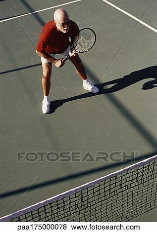 Stock Photo - Mature man playing tennis. Fotosearch