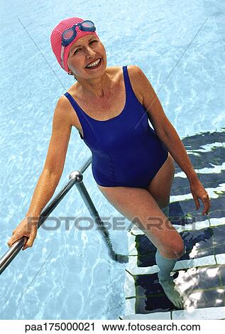 Mature woman coming out of swimming pool, smiling View Large Photo Image Stock Image - Mature woman coming out of swimming pool, smiling. Fotosearch