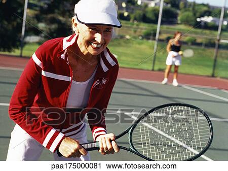 Mature woman holding tennis racket, smiling View Large Photo Image Stock Image - Mature woman holding tennis racket, smiling. Fotosearch