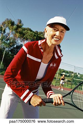 Mature woman holding tennis racket, portrait View Large Photo Image Stock Photograph - Mature woman holding tennis racket, portrait. Fotosearch