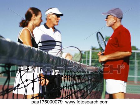 Three mature tennis players on court, side view View Large Photo Image Stock Photo - Three mature tennis players on court, side view. Fotosearch