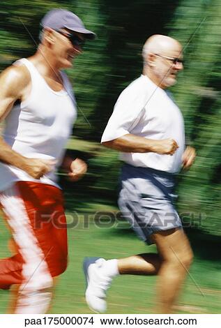 Two mature joggers in park, blurred motion View Large Photo Image Picture - Two mature joggers in park, blurred motion. Fotosearch