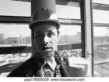 Stock Photo - Builder wearing hard hat, close-up, b&w. Fotosearch
