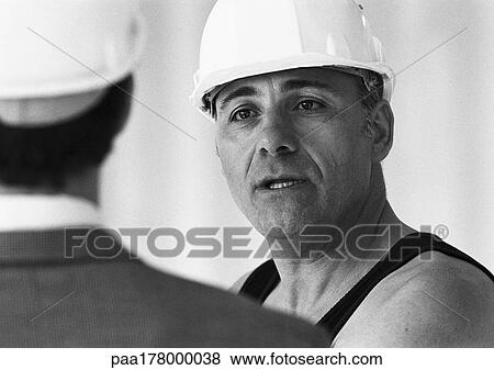 Builders wearing hard hats, close-up, b&w View Large Photo Image Stock Photo - Builders wearing hard hats, close-up, b&w. Fotosearch