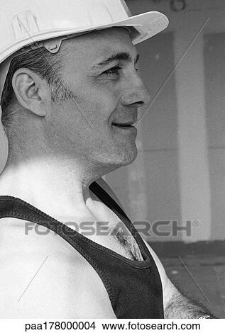 Picture - Construction worker wearing hard hat, side view, b&w. Fotosearch