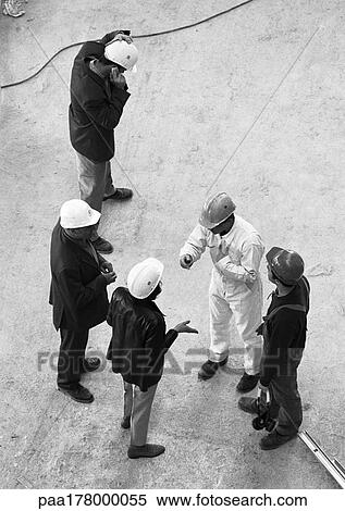 Stock Photography - Five people wearing hard hats, elevated view, b&w. Fotosearch