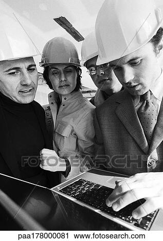 Four people wearing hard hats, one using laptop computer, b&w View Large Photo Image Stock Image - Four people wearing hard hats, one using laptop computer, b&w. Fotosearch