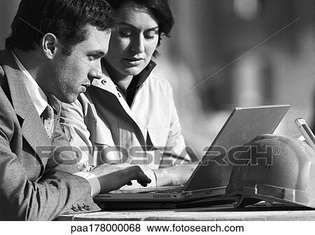 Man and woman looking at laptop computer, b&w View Large Photo Image Stock Photo - Man and woman looking at laptop computer, b&w. Fotosearch