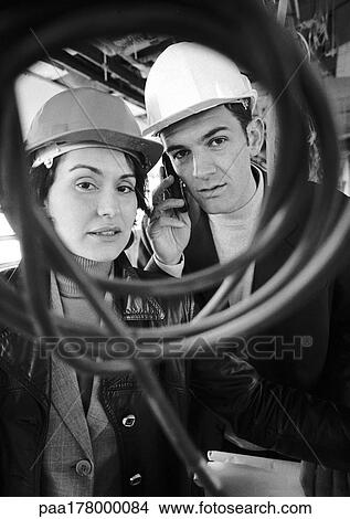 Picture - Man and woman wearing hard hats, portrait, b&w. Fotosearch