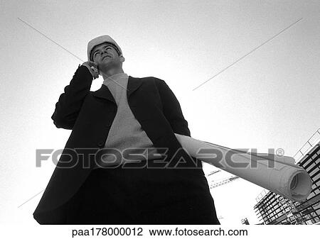 Man with hard hat, using cell phone, low angle view, b&w View Large Photo Image Stock Image - Man with hard hat, using cell phone, low angle view, b&w. Fotosearch