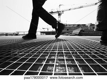 Stock Photo - Person walking on construction site, low section. Fotosearch