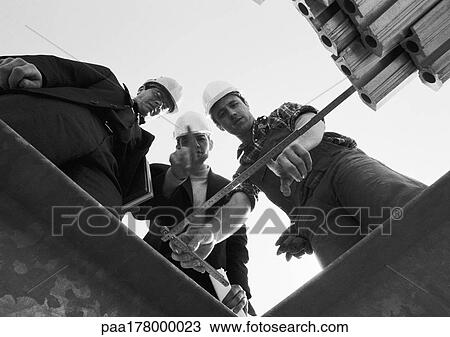 Three men looking at folding ruler, low angle view, b&w View Large Photo Image Stock Image - Three men looking at folding ruler, low angle view, b&w. Fotosearch