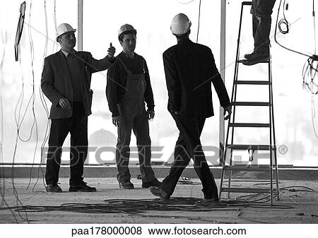 Three men wearing hard hats on building site View Large Photo Image Stock Photo - Three men wearing hard hats on building site. Fotosearch