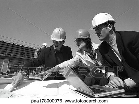 Three people with hard hats examining blueprints, b&w View Large Photo Image Stock Photograph - Three people with hard hats examining blueprints, b&w. Fotosearch