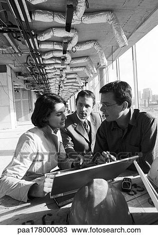 Stock Image - Two men and woman in front of laptop computer, b&w. Fotosearch