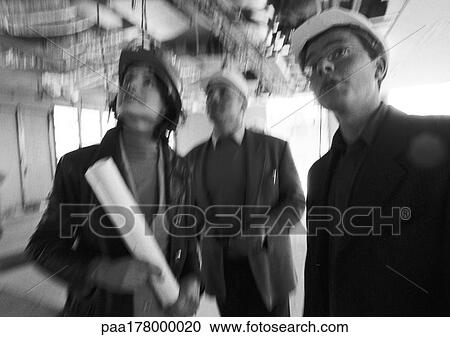 Two men and woman wearing hard hats, blurred, b&w View Large Photo Image Stock Image - Two men and woman wearing hard hats, blurred, b&w. Fotosearch
