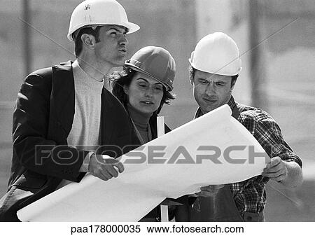 Two men and woman with hard hats examining blueprints, b&w View Large Photo Image Stock Photography - Two men and woman with hard hats examining blueprints, b&w. Fotosearch