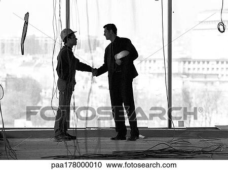 Two men with hard hats, shaking hands, b&w View Large Photo Image Stock Image - Two men with hard hats, shaking hands, b&w. Fotosearch