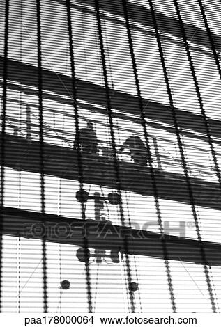 Two people on scaffolding, b&w View Large Photo Image Picture - Two people on scaffolding, b&w. Fotosearch