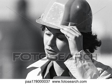 Woman holding hard hat, close-up, b&w View Large Photo Image Stock Photo - Woman holding hard hat, close-up, b&w. Fotosearch