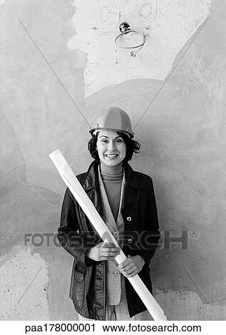 Stock Image - Woman wearing hard hat, portrait, b&w. Fotosearch