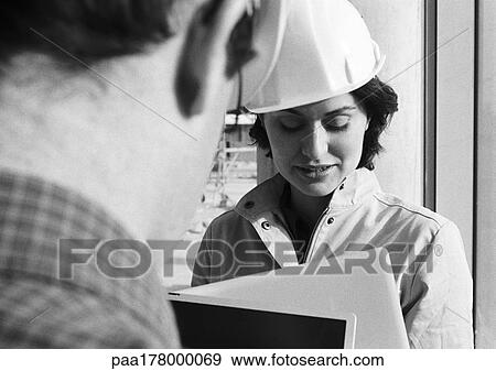 Woman with hard hat, examining documents, b&w View Large Photo Image Stock Photo - Woman with hard hat, examining documents, b&w. Fotosearch