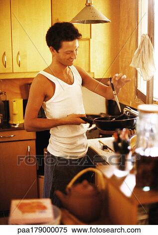 Stock Photography - Man cooking in kitchen. Fotosearch