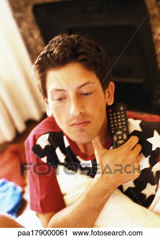 Man holding remote control in hand and pillow under arm View Large Photo Image Stock Image - Man holding remote control in hand and pillow under arm. Fotosearch