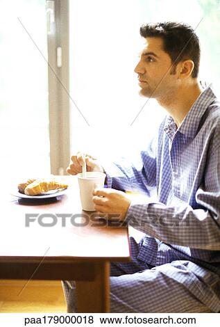 Man in pajamas having breakfast View Large Photo Image Stock Photo - Man in pajamas having breakfast. Fotosearch