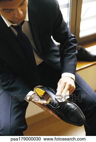 Man in suit polishing shoe, close-up View Large Photo Image Stock Image - Man in suit polishing shoe, close-up. Fotosearch